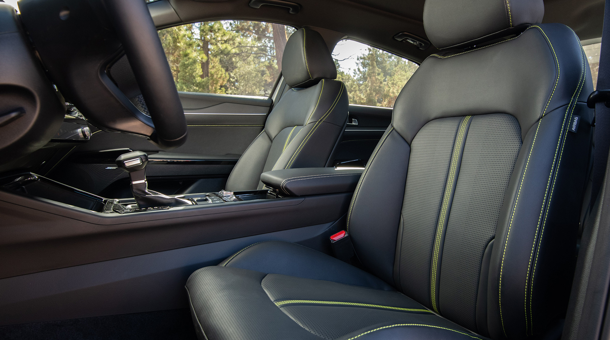 Interior of a 2025 Kia K5 highlighting the pilot's seats and available panoramic sunroof