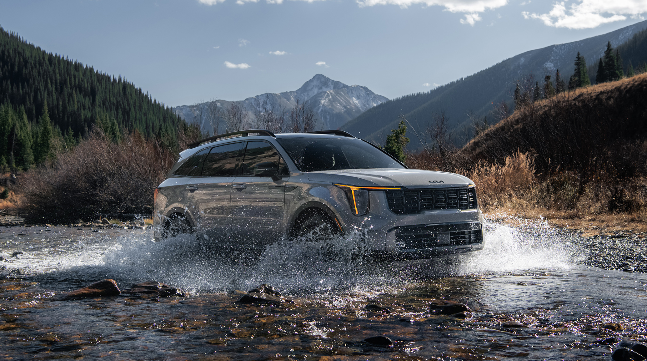 2025 Kia Sorento, three-quarter view, driving through a river making a big splash