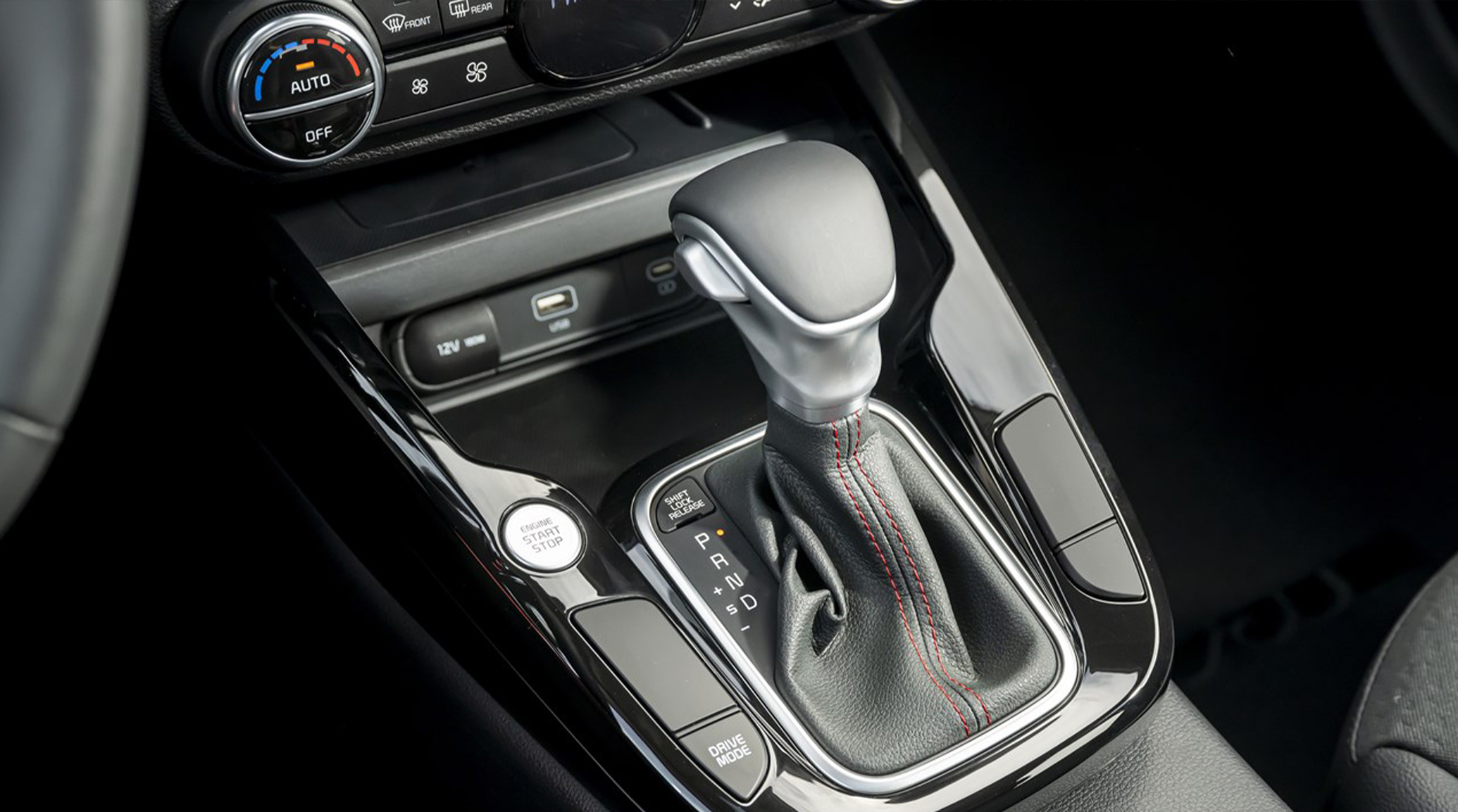 2025 Kia Soul interior, zoomed in view of the gear shifter, featuring the engine start button beside it