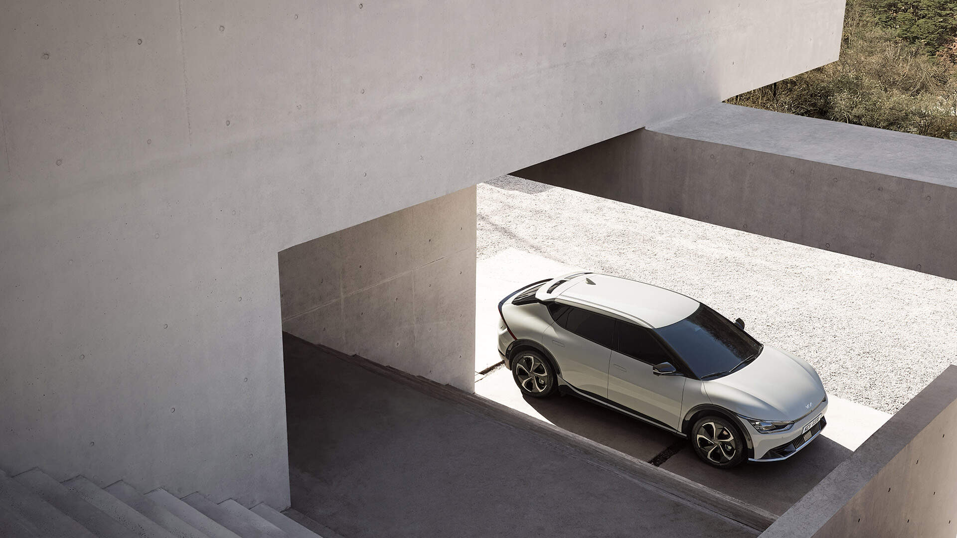 A white Kia EV6 parked in front of a concrete building