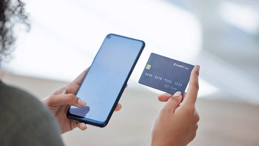 Woman's hands holding a smartphone and credit card
