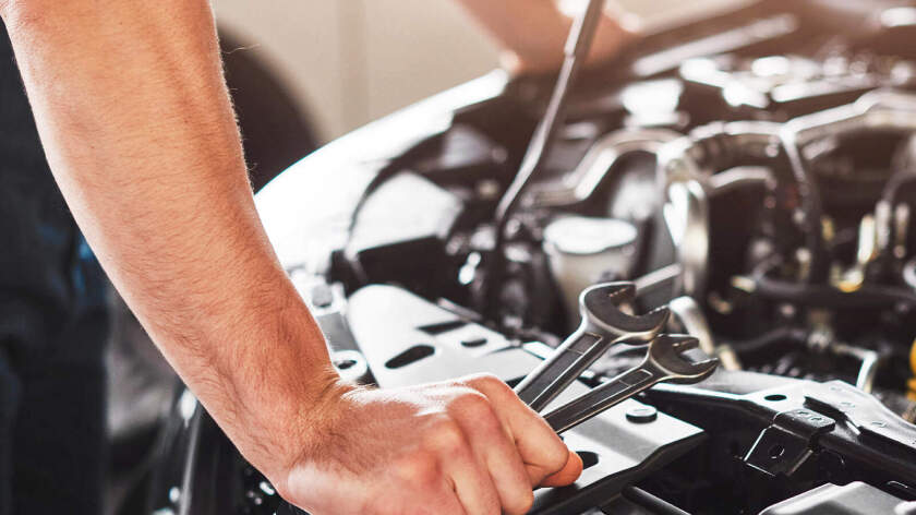 Mecánico reparando un coche con una llave inglesa