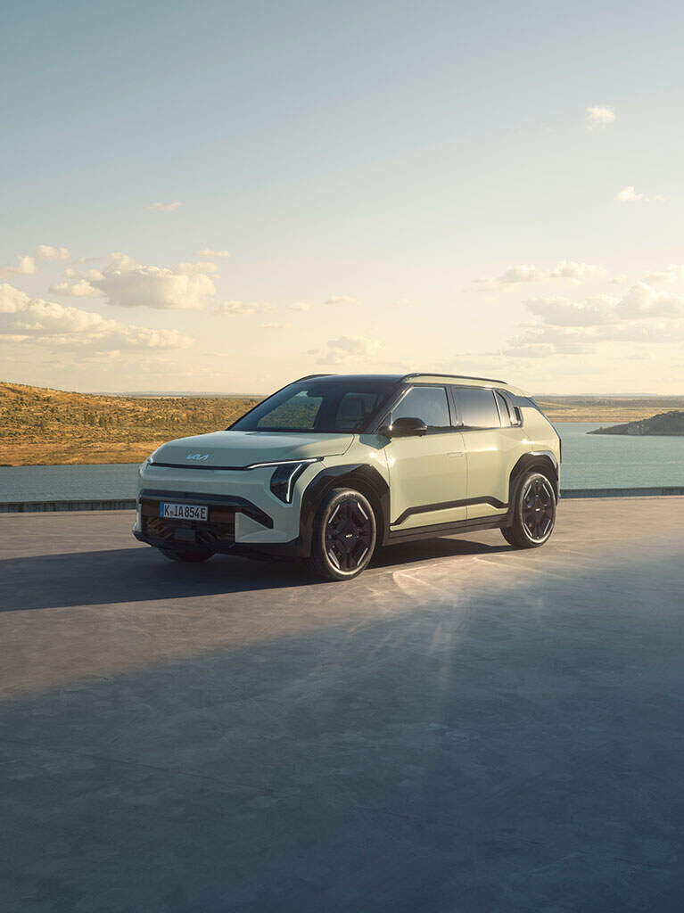 A Kia EV3 on a concrete platform near a lake