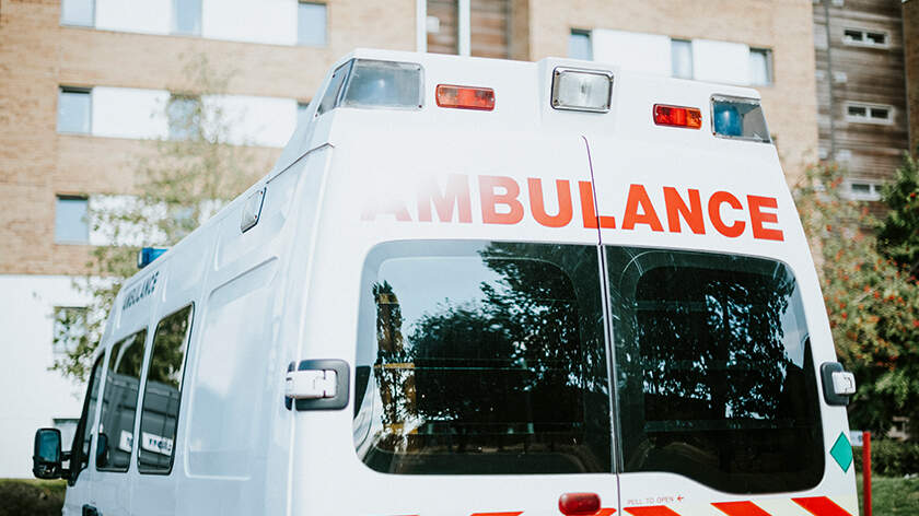 Close-up of the back of an ambulance, which is parked in front of a building