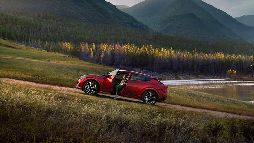 Woman relaxing in driver's seat of the EV6 in nature