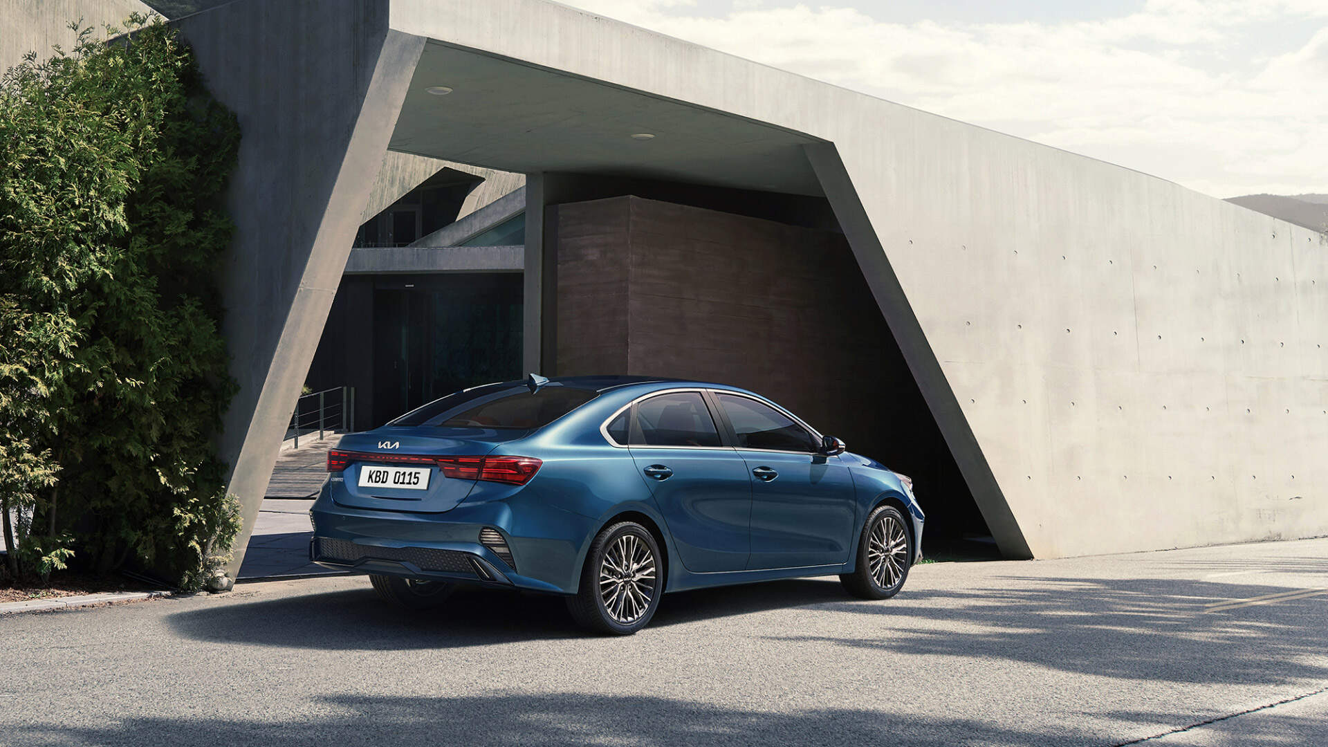 Kia Cerato is parked in front of the door of a concrete house