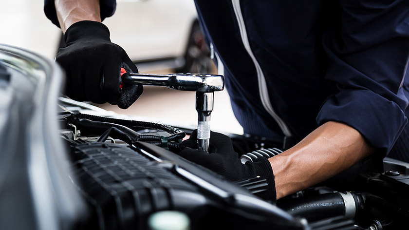 Mechanic repairing a car using a wrench
