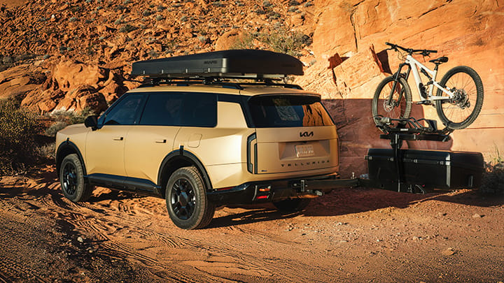 A close-up image of a rear-seat entertainment system in the 2027 Kia Telluride featuring two Kia accessories mounted on black headrests.