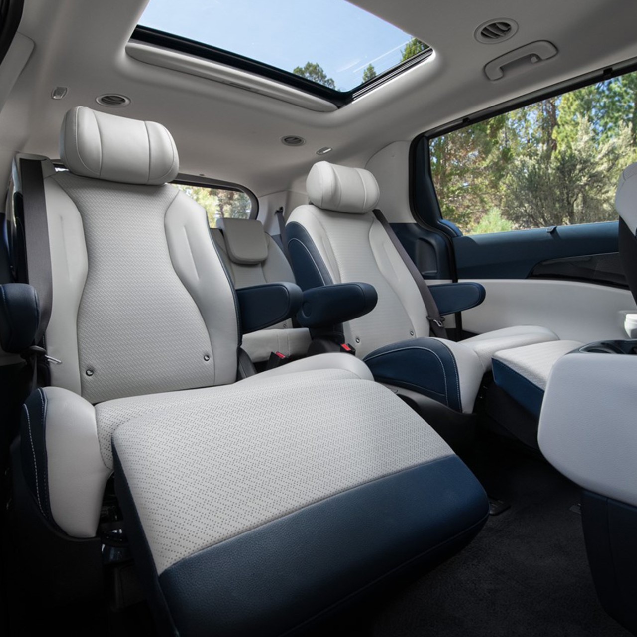 2025 Kia Carnival MPV Hybrid interior, three-quarter view of the VIP Lounge Seats with the footrests up